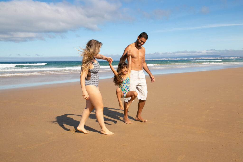 Famille heureuse sur une plage ensoleillée, illustrant les meilleures destinations où s'expatrier en famille au soleil.