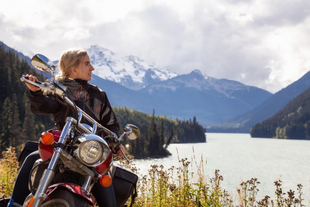 Budget pour un voyage moto au Cap Nord : coûts et conseils pratiques 1 Motard sur la route du Cap Nord avec vue sur les fjords norvégiens
