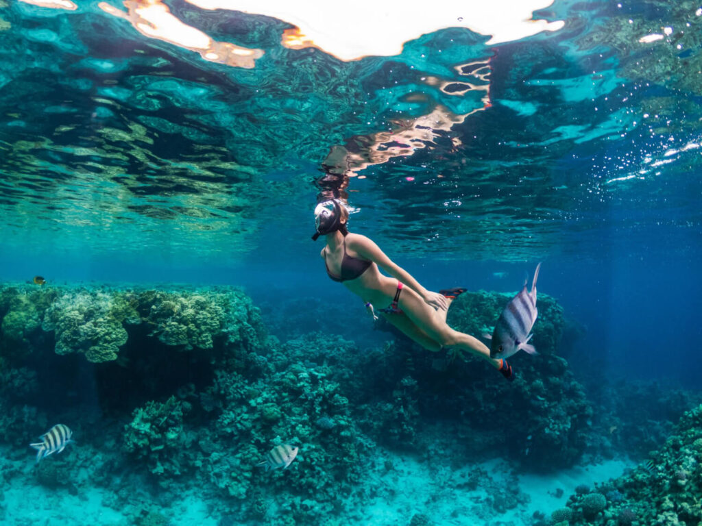 Personne faisant du snorkeling dans une eau turquoise et cristalline près de rochers à Koh Samui, Thaïlande, illustrant les meilleurs spots de l'île.