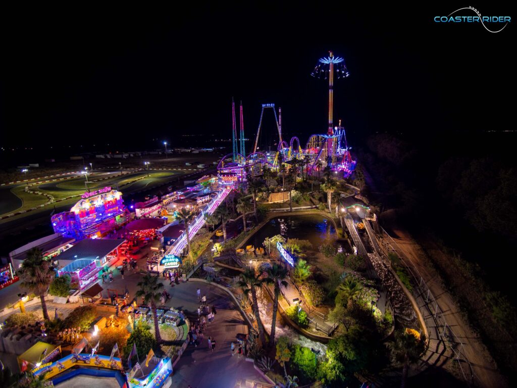 Grande roue et attractions du parc Fabrikus World illuminé la nuit, pour un avis sur le parc.