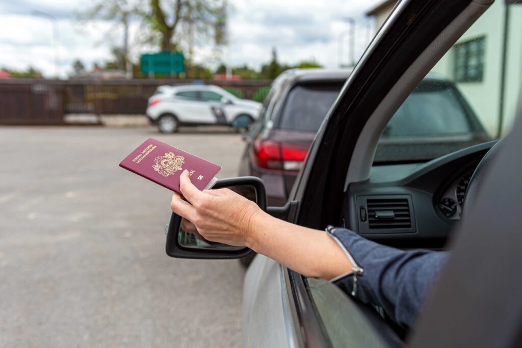 Homme qui tien son passeport dans sa voiture