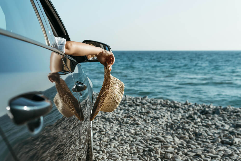 Comment se rendre à l'Île-Tudy en voiture ? 1 Voiture roulant sur la digue du Sillon qui relie l'Île-Tudy au continent, avec la mer de chaque côté.