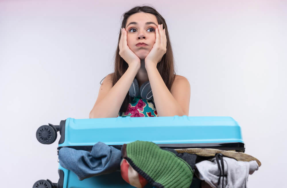 Billet électronique eDreams non reçu : que faire ? 4 femme avec une valise remplie inquiete de ne pas avoir reçue ses Billet électronique eDreams