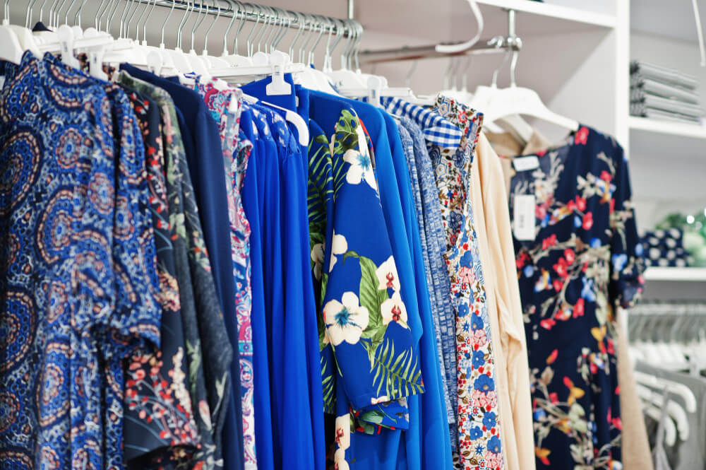 Quel est le prix des vêtements à Bali ? 2 Intérieur d'une boutique à Bali avec des robes d'été colorées et des vêtements légers sur des portants.