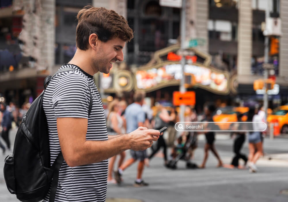 Voyageur utilisant son smartphone en mode GPS dans une rue étrangère.