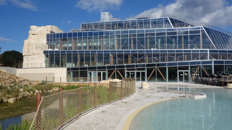 Vue extérieure de l'Aqualagon de Villages Nature Paris, avec ses toboggans et sa pyramide.