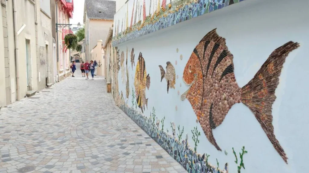 Comment aller au quartier de l'Île Penotte aux Sables d'Olonne ? 2 Fresque murale en coquillages dans une ruelle étroite du quartier de l'Île Penotte.
