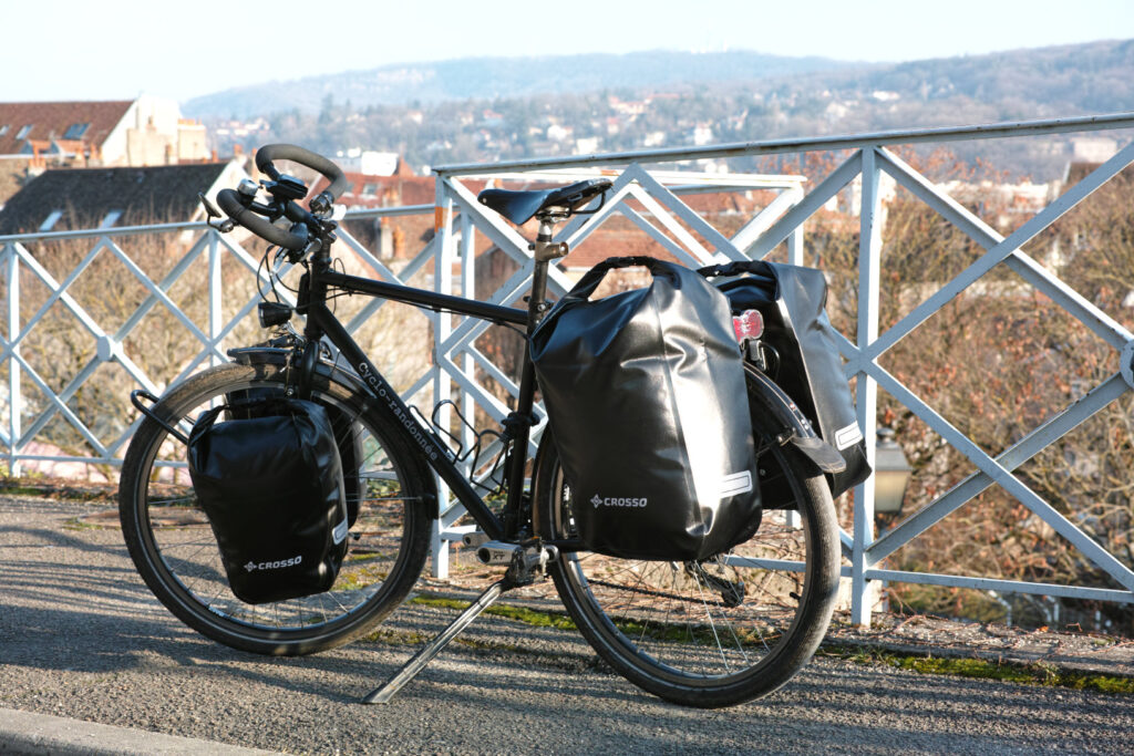 Vélo de randonnée chargé avec des sacoches étanches Crosso Dry à l'arrière.