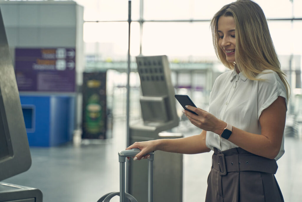 Un voyageur scannant un QR code sur son smartphone pour activer son forfait internet eSIM dans un aéroport.