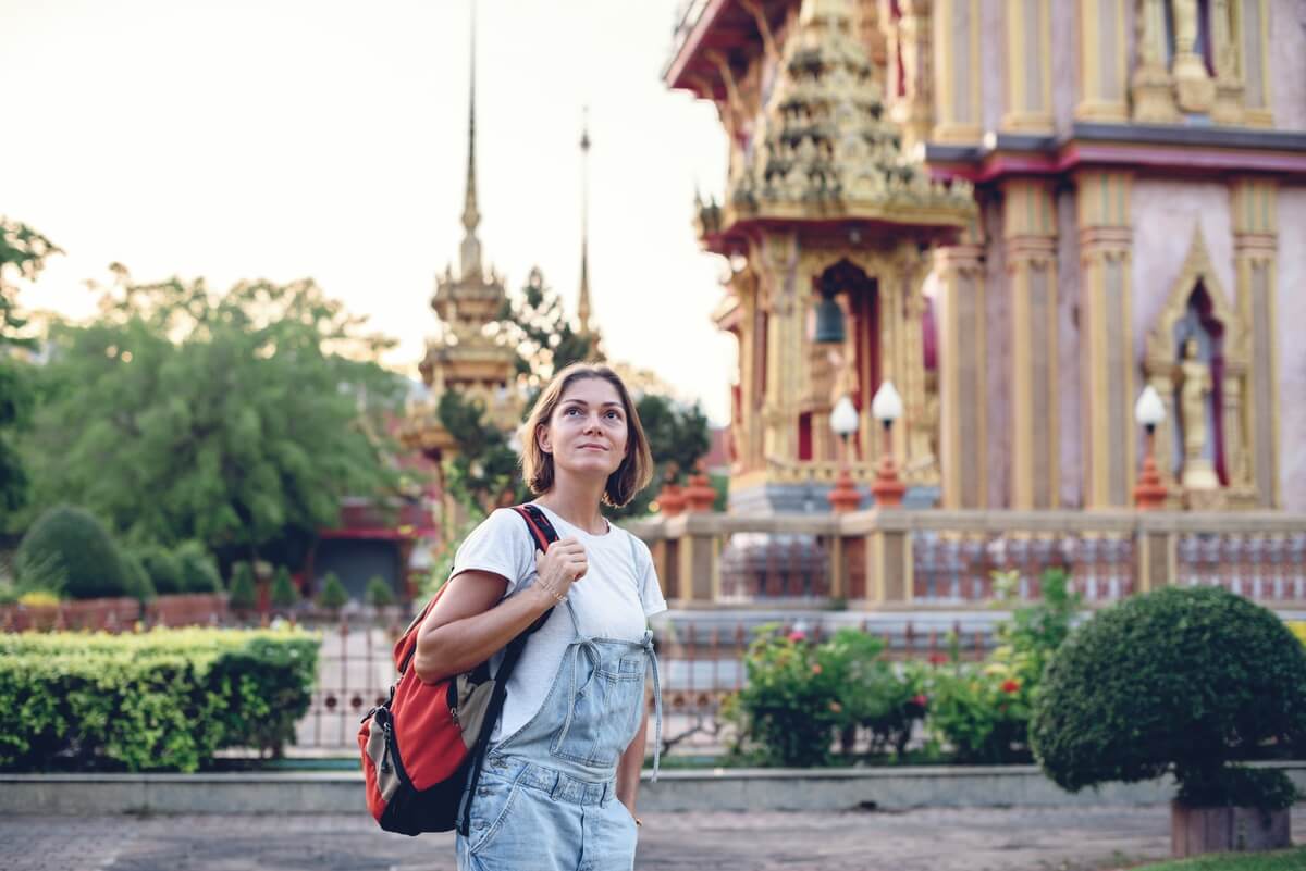 Une femme voyageant seule admirant l'architecture d'un temple à Luang Prabang au Laos.