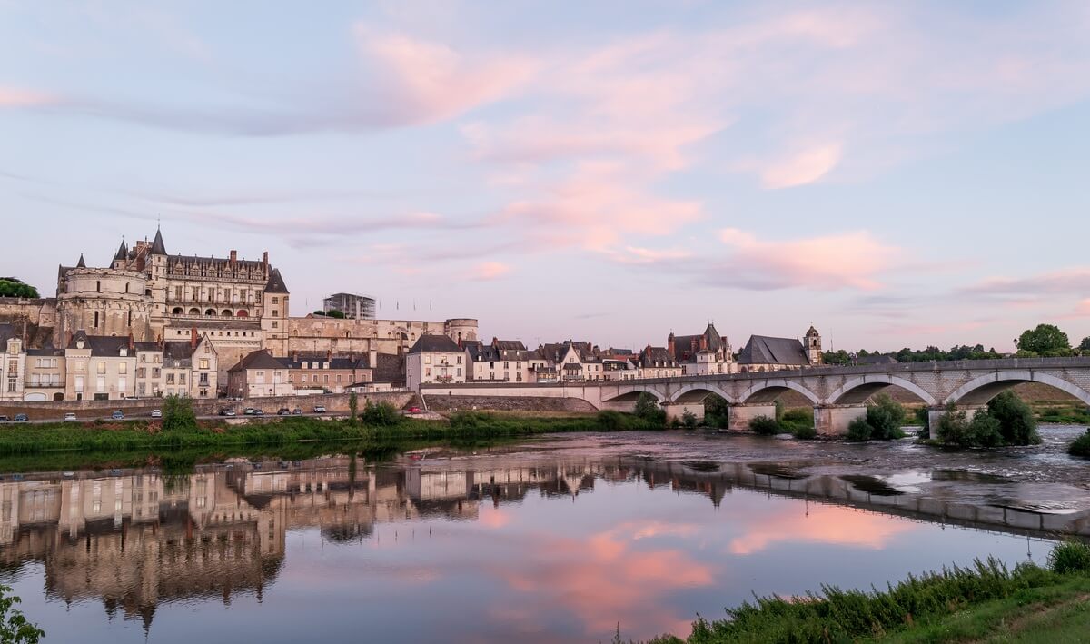 Un château emblématique de la Touraine surplombant la Loire lors d'un coucher de soleil.