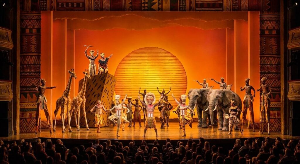 Costumes et mise en scène spectaculaire de la comédie musicale Le Roi Lion sur une scène de Broadway.