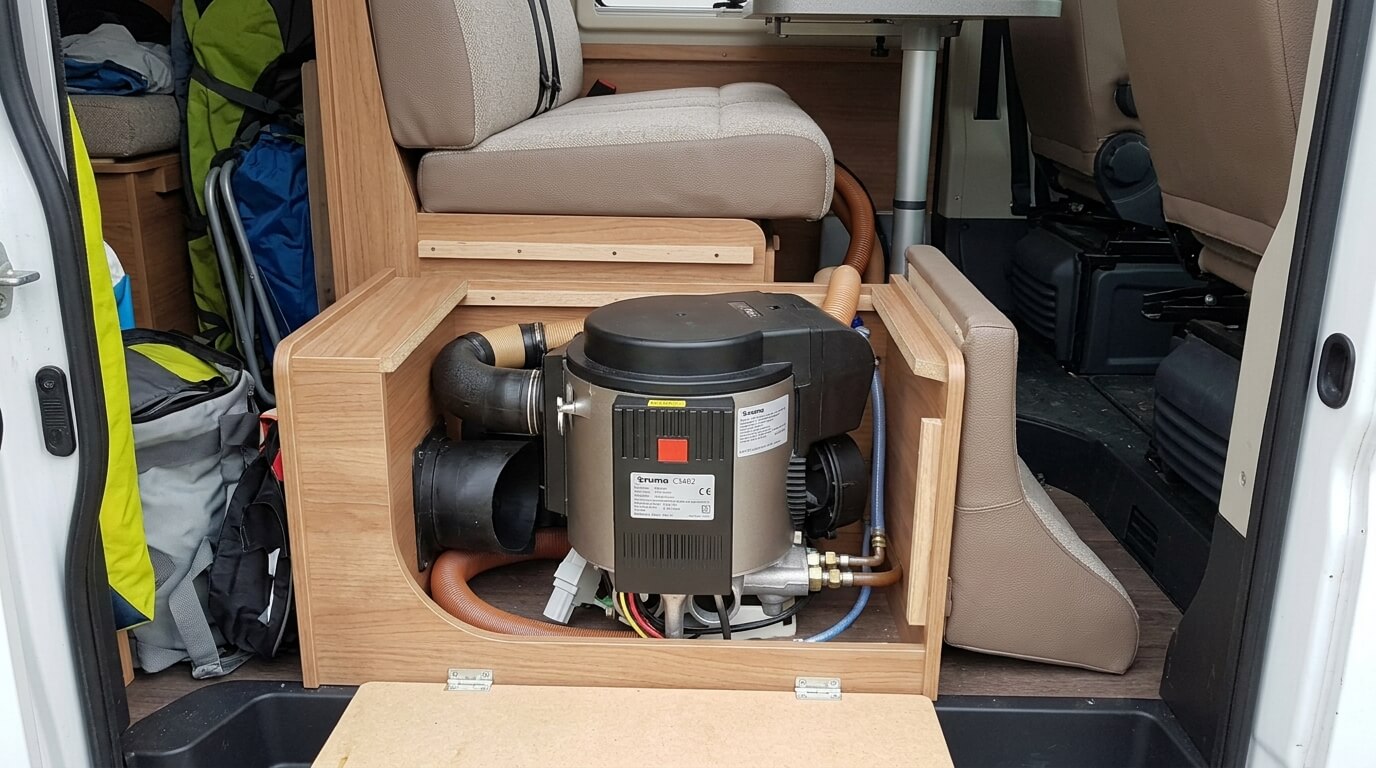 L'appareil combiné chauffage et bocal d'eau chaude Truma C3402 installé sous une banquette de camping-car.