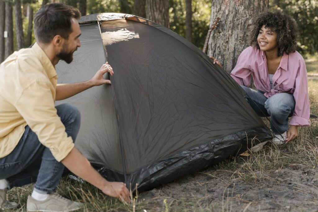 Une tente de camping installée sur un emplacement ombragé au cœur de la nature.
