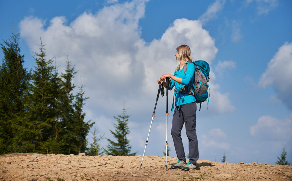 Comment bien choisir ses chaussures de randonnée pour femme pour voyager confortablement ? 3 Une femme marchant confortablement sur un sentier de randonnée en voyage avec ses chaussures adaptées.